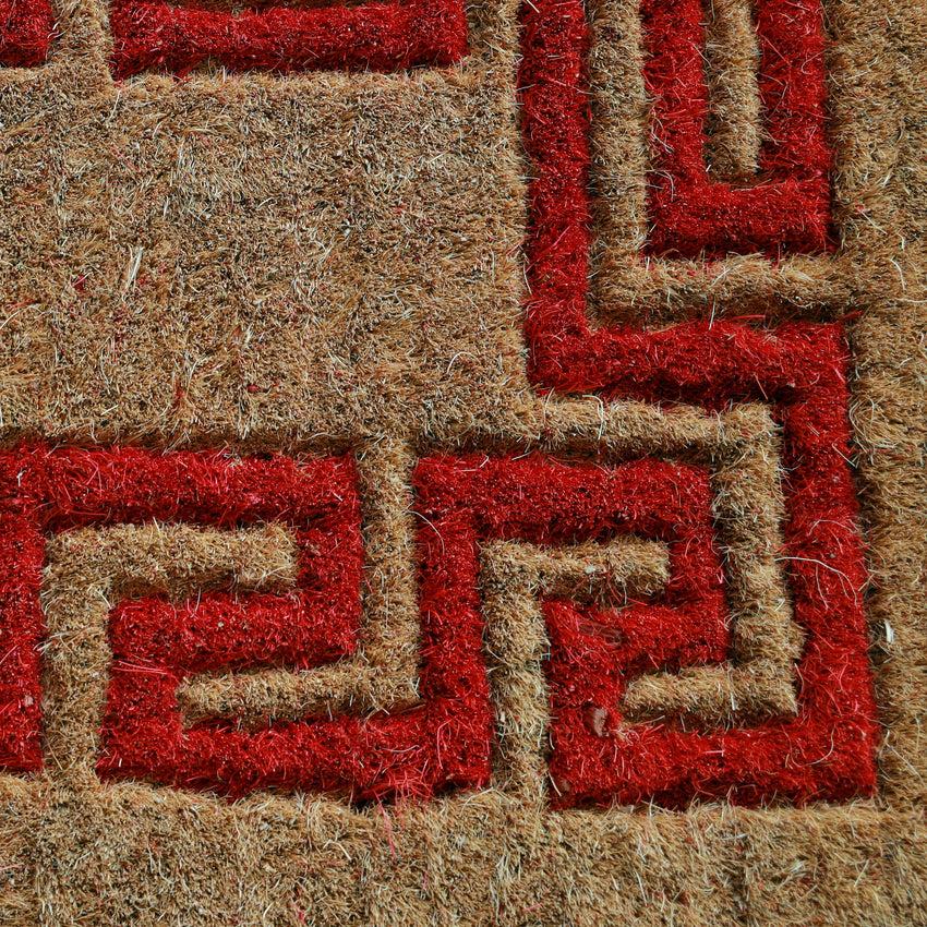 Eco-friendly MyMats coir doormat in red and beige placed at the main door—suitable for outdoor or indoor entrances.