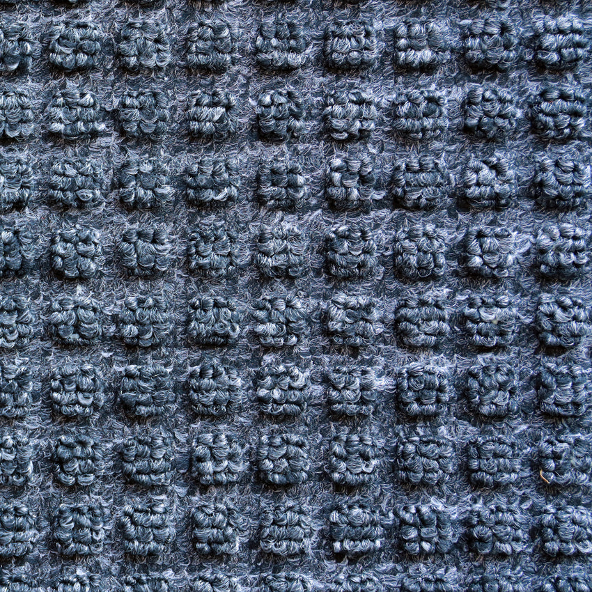 Stylish blue surface mat with heavy-duty black rubber base, perfect for entrances